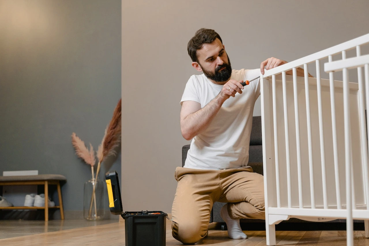 A dad fixing a crib