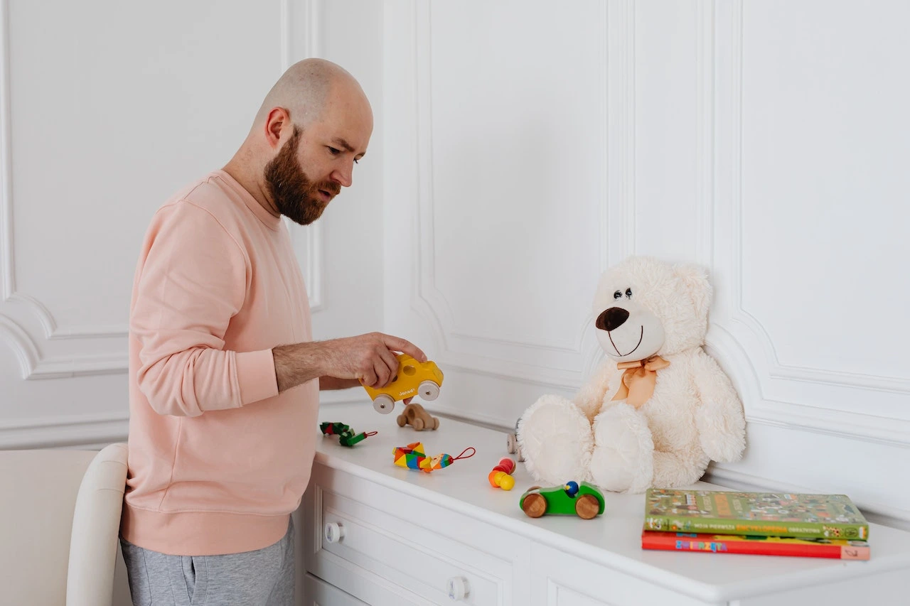 A dad cleaning up toys